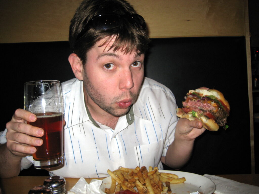 Laurent with a bitchin' burger and a beer.